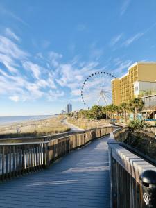a boardwalk along the beach with a ferris wheel at Newly Renovated Ocean Front Condo, Modern Decor, Central MB, 20th floor in Myrtle Beach