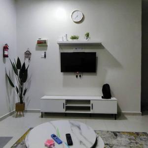 uma sala de estar com uma televisão de ecrã plano numa parede branca em Firdzura Home Semi D em Kuantan
