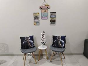 dos sillas con una foto de un hombre hablando por celular en Firdzura Home Semi D en Kuantan