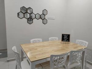 a dining room table with chairs and a sign on the wall at Firdzura Home Semi D in Kuantan