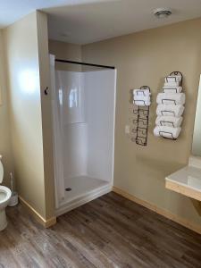 a bathroom with a shower and a toilet and towels at Canary Beach Resort in Glenwood