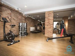un gimnasio con máquinas de ejercicio en una pared de ladrillo en White Apartment, en Gdansk