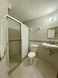 a bathroom with a shower and a toilet and a sink at Hotel Real del Quijote a sólo 50 metros de la playa in Tecolutla