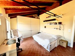 1 dormitorio con cama blanca, escritorio y silla en Country house 15km from Bologna, en Budrio