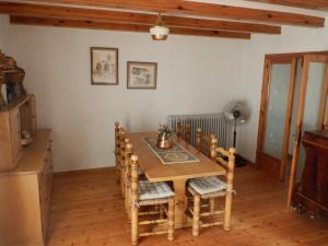 a dining room with a wooden table and chairs at Cal Abel in Gombreny