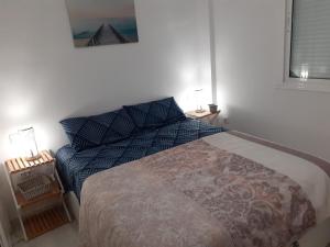 Un dormitorio con una cama con almohadas azules. en Appartement avec vue sur baie de Malaga, en Torre de Benagalbón