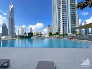 a large swimming pool in a city with tall buildings at Stunning 2Bedroom with balcony Dubai Mall access in Dubai