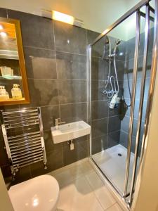 une salle de bain avec une douche, des toilettes et un lavabo dans l'établissement Cowdale Cottage, à York 15 autres photos