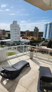 a balcony with a bench and a view of a city at Departamento Pinamar Centro Status Tower in Pinamar
