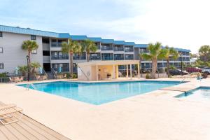 a large swimming pool in front of a building at Palm Peach Tybee - Balcony - Oceanview "It's like, really pretty!" in Tybee Island