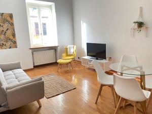 ローマにあるVolupta's House Janiculum Hillのリビングルーム(ガラステーブル、白い椅子付)