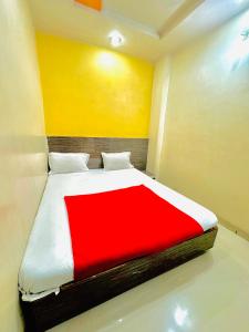 a bedroom with a bed with a red and white blanket at GRK Hotel - Near Shri Saibaba Temple in Shirdi
