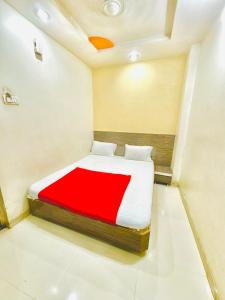 a bedroom with a bed with a red blanket at GRK Hotel - Near Shri Saibaba Temple in Shirdi