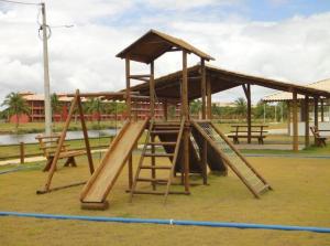 a playground with a wooden play structure with a slide at Villa das Águas - Praia do Saco - SE in Estância