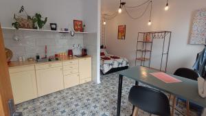 a kitchen with a table and a room with a bed at Porta Red in Budapest