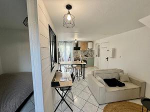 a living room with a couch and a kitchen at La Pause Moirannaise in Moirans