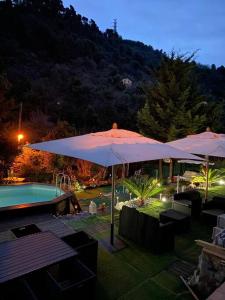 eine Terrasse mit einem Sonnenschirm und einem Pool in der Unterkunft Petit coin de paradis in Menton