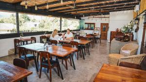 two people sitting at tables in a restaurant at Cava Colchagua Hotel Boutique in Santa Cruz