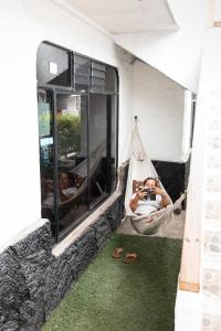 a person lying in a hammock taking a picture at Hotel LA GRAN TORTUGA - ᯤ STARLINK in Puerto Villamil