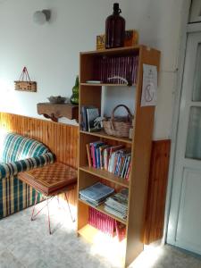 uma prateleira cheia de livros ao lado de um sofá em RHOMBUS HOSPEDAJE Y HABITACIONES em Guaymallén