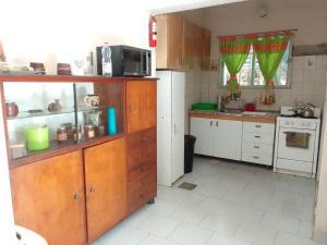 a kitchen with wooden cabinets and a counter top at RHOMBUS HOSPEDAJE Y HABITACIONES in Guaymallen