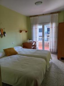 2 camas en una habitación de hotel con ventana en Pis de l'Hereu., en La Pobla de Segur