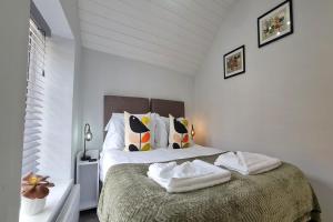 1 dormitorio blanco con 1 cama grande y 2 almohadas en Beam End Snainton - Modern 2-bedroom Stone Cottage en Snainton