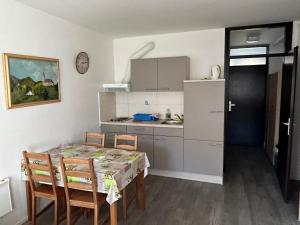 una cucina con tavolo e sedie e una cucina con bancone di Apartment Aly a Bovec