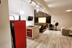 cocina y sala de estar con nevera roja en Loft Alto Nível Teresópolis, en Teresópolis