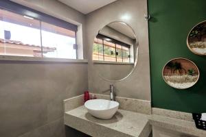 un baño con lavabo y espejo en Loft Alto Nível Teresópolis, en Teresópolis 20 fotos más