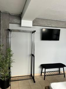 Habitación con pared blanca, mesa y TV. en TheLoft, en Kavala