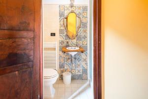 La salle de bains est pourvue de toilettes et d'un miroir jaune. dans l'établissement Noli centro, Ampia Casa stile Kinfolk + Parcheggio, à Noli