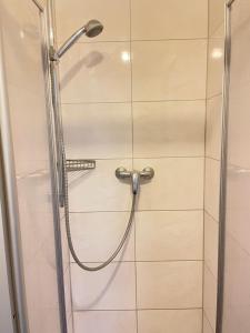 a shower with a hose in a bathroom at Pension Nierstein bei Mainz in Nierstein