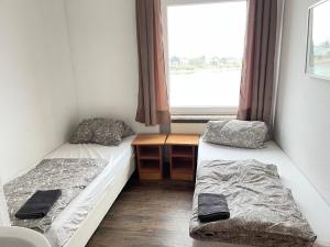 two beds in a room with a window at Pension Nierstein bei Mainz in Nierstein