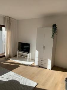 a living room with a large white cabinet and a tv at Ferienwohnung Panorama Schwarzwald in Herrischried