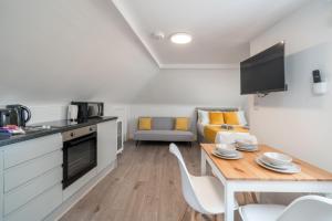a kitchen and living room with a table and chairs at Cosy 4th Floor studio apartment in Brick Lane in London
