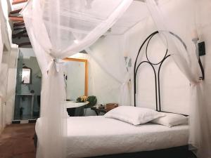 ein weißes Bett mit Baldachin in einem Zimmer in der Unterkunft Hotel Casa del Ángel in Villavieja