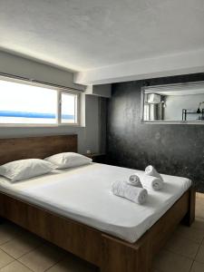 1 dormitorio con 1 cama grande y toallas. en TheLoft, en Kavala