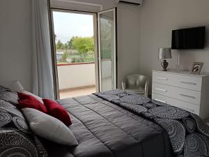 Un dormitorio con una cama con almohadas rojas y una ventana en Parco delle Rose, en Sulmona
