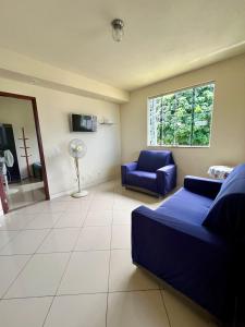 a living room with a blue couch and a window at Adialas Tour Angra dos Reis! in Angra dos Reis