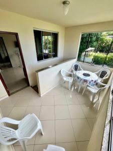 a room with a table and chairs on a balcony at Adialas Tour Angra dos Reis! in Angra dos Reis