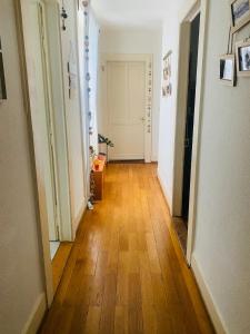 a hallway with a wooden floor and white walls at Chambre double Montreux centre vue lac in Montreux