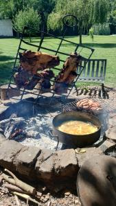 una olla de comida está cocinando sobre un pozo de fuego en QuintaLasBoleadoras en General Rodríguez