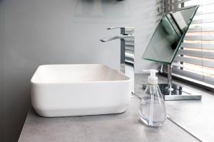 baño con lavabo blanco y botella de jabón en Beam End Snainton - Modern 2-bedroom Stone Cottage en Snainton