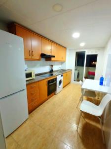 a kitchen with a white refrigerator and a table at Precioso piso in Catarroja
