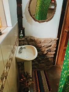 y baño con lavabo y espejo. en Cabaña del viajero., en Ollantaytambo
