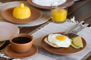 a breakfast plate with an egg and a cup of coffee at Casa Canoa - Praia de Algodões in Marau