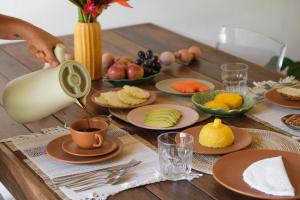 a table with plates of food and a jug of coffee at Casa Canoa - Praia de Algodões in Marau