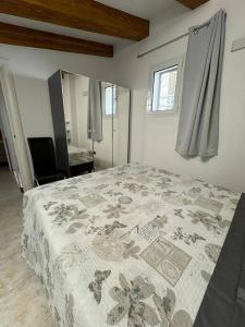 una camera da letto con un letto con una coperta sopra di La Maison de Luisa a Bordighera
