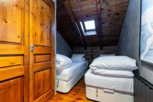 エル・タルテルにあるPleta del Tarter Lodgeのベッド2台とドアが備わる小さな部屋です。
